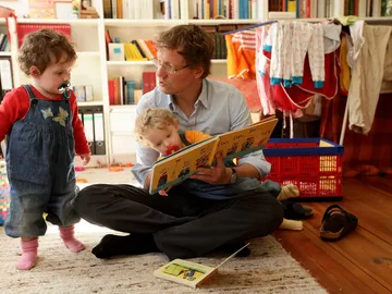 Un padre cuidando de sus hijos Un padre cuidando de sus hijos