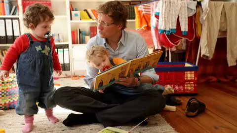 Un padre cuidando de sus hijos Un padre cuidando de sus hijos