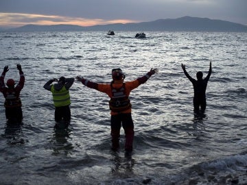 Varios voluntarios aguardan en la costa a la llegada de refugiadosVarios voluntarios aguardan en la costa a la llegada de refugiados