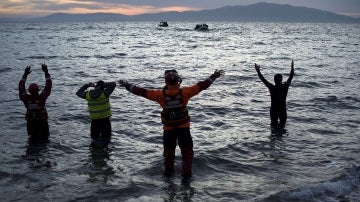 Varios voluntarios aguardan en la costa a la llegada de refugiadosVarios voluntarios aguardan en la costa a la llegada de refugiados