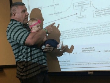 El profesor sosteniendo a la bebé