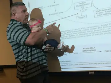 El profesor sosteniendo a la bebé El profesor sosteniendo a la bebé