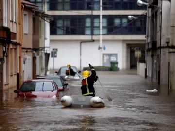 Dos bomberos atravesan una de las calles del concello de Sada