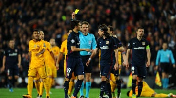 Felix Brych muestra una cartulina a un jugador del Atlético