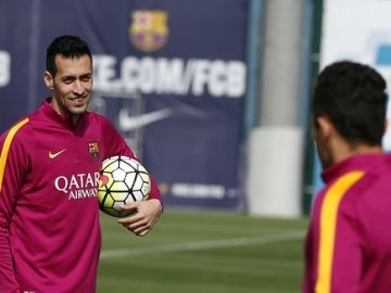 Busquets sonríe ante la mirada de Piqué