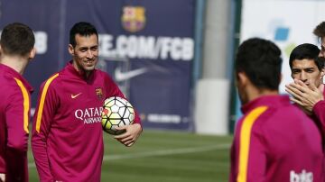 Busquets sonríe ante la mirada de Piqué