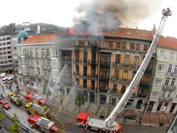 El edificio incendiado en Oviedo se derrumba con un bombero dentro