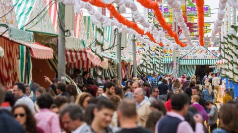 P&uacute;blico camina por El Real de la Feria de Abril de Sevilla