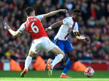 Wilfried Zaha del Crystal Palace se lleva el balón ante Laurent Koscielny del Arsenal 