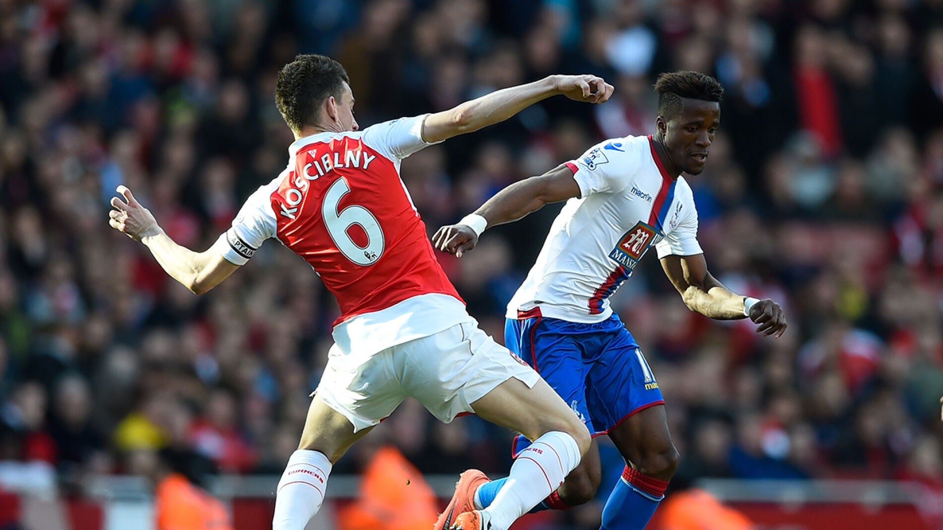 Wilfried Zaha del Crystal Palace se lleva el bal&oacute;n ante Laurent Koscielny del Arsenal 
