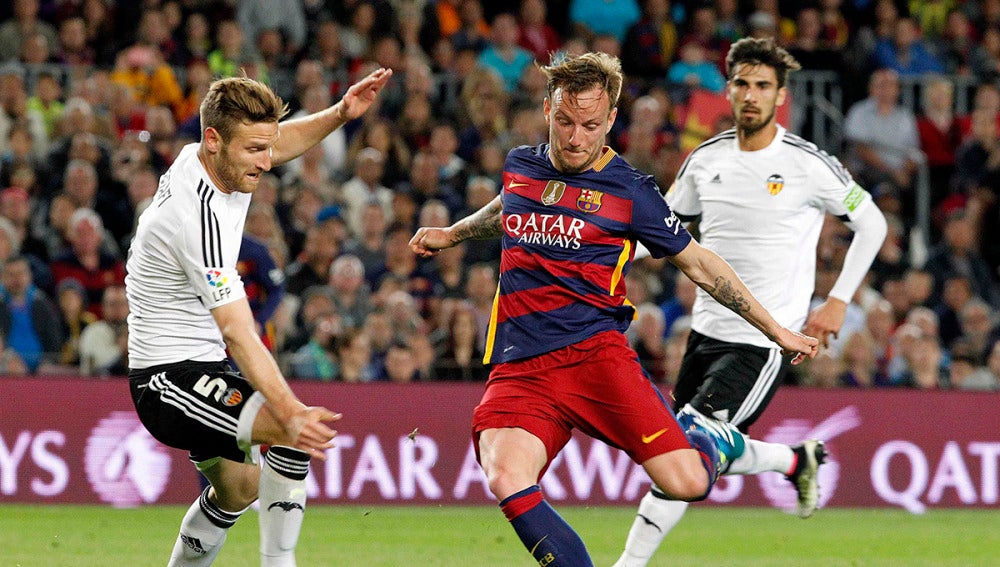  Ivan Rakitic dispara junto al alemán Mustafi, del Valencia CF, durante el partido