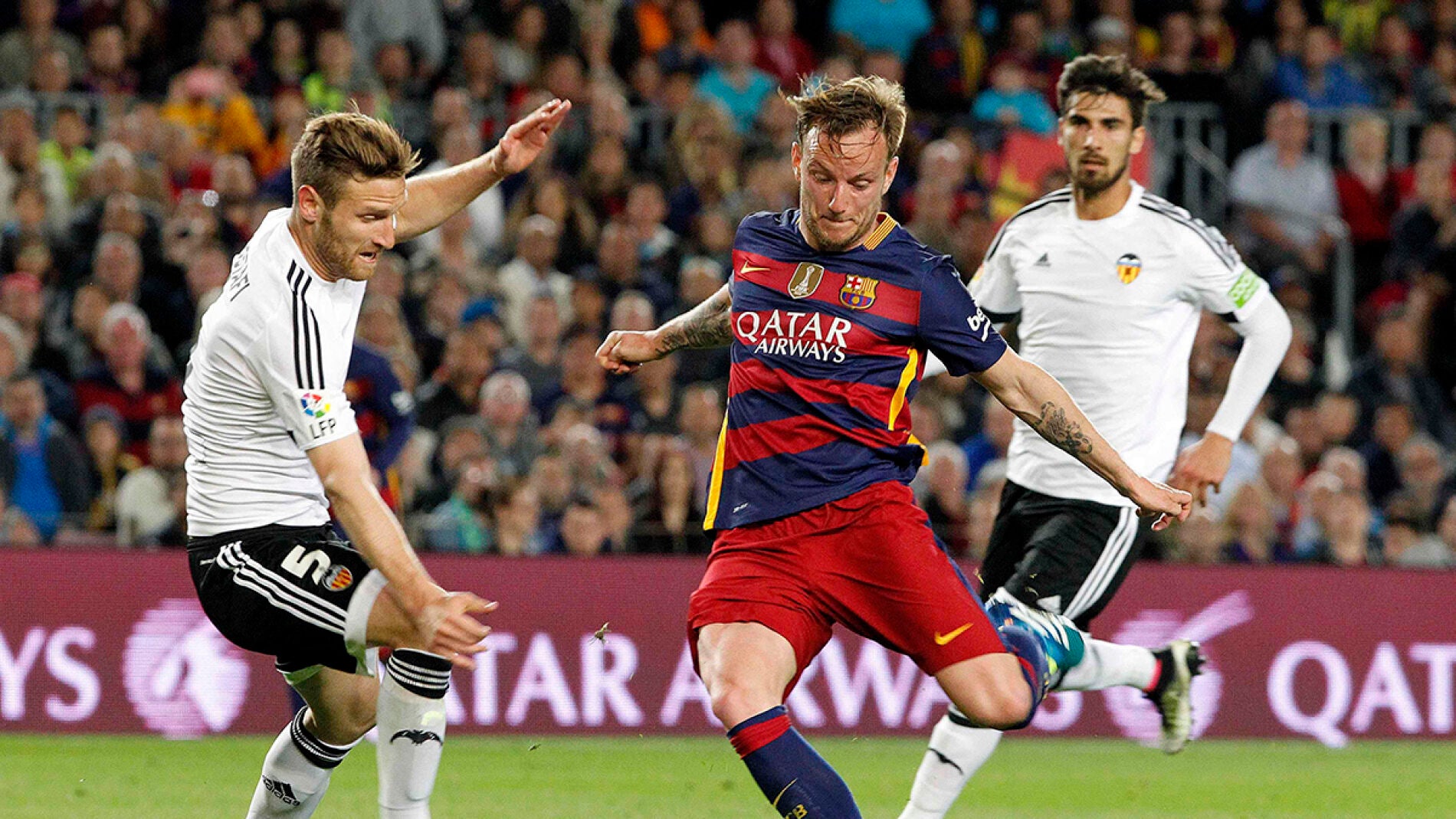  Ivan Rakitic dispara junto al alem&aacute;n Mustafi, del Valencia CF, durante el partido