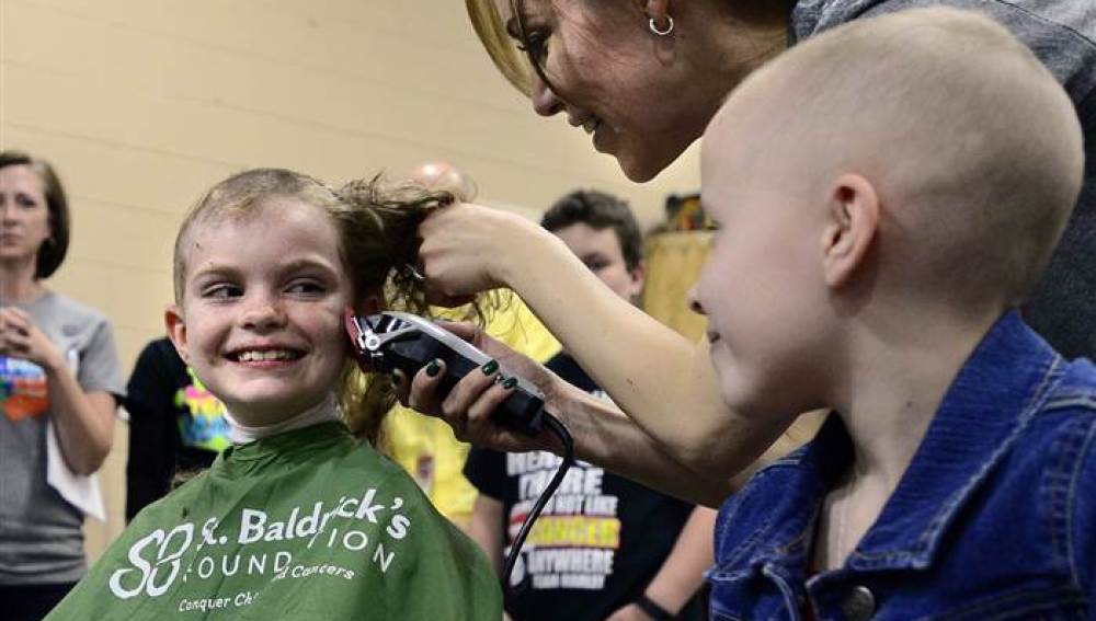 Una niña con cáncer rapándose con el apoyo de sus compañeros