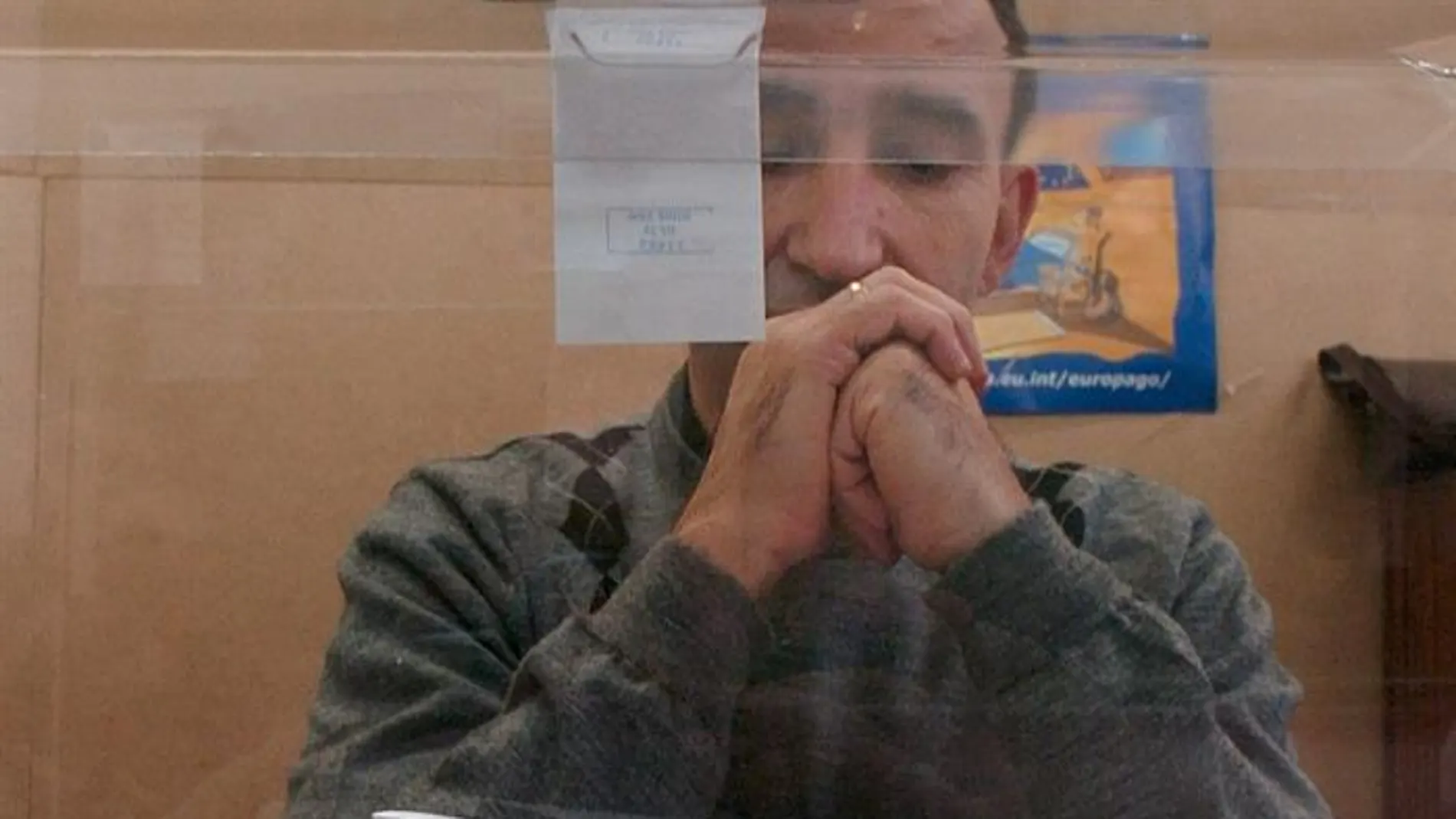 Un miembro de una mesa electoral observa los votos Un miembro de una mesa electoral observa los votos