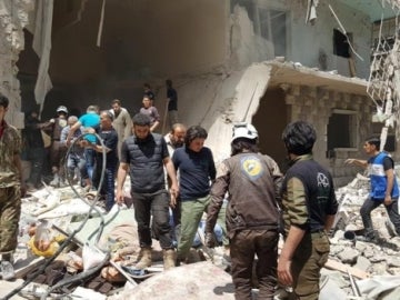 Sirios en el lugar de los ataques aéreos en el barrio Bustan Al Qasr