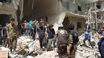 Sirios en el lugar de los ataques aéreos en el barrio Bustan Al Qasr