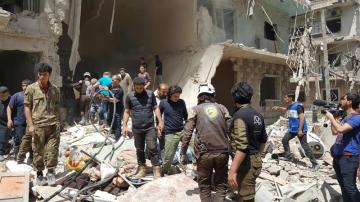 Sirios en el lugar de los ataques aéreos en el barrio Bustan Al Qasr