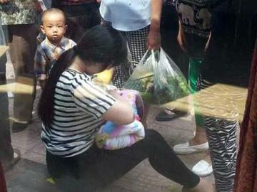 La mujer amamanta al pequeño en la calle