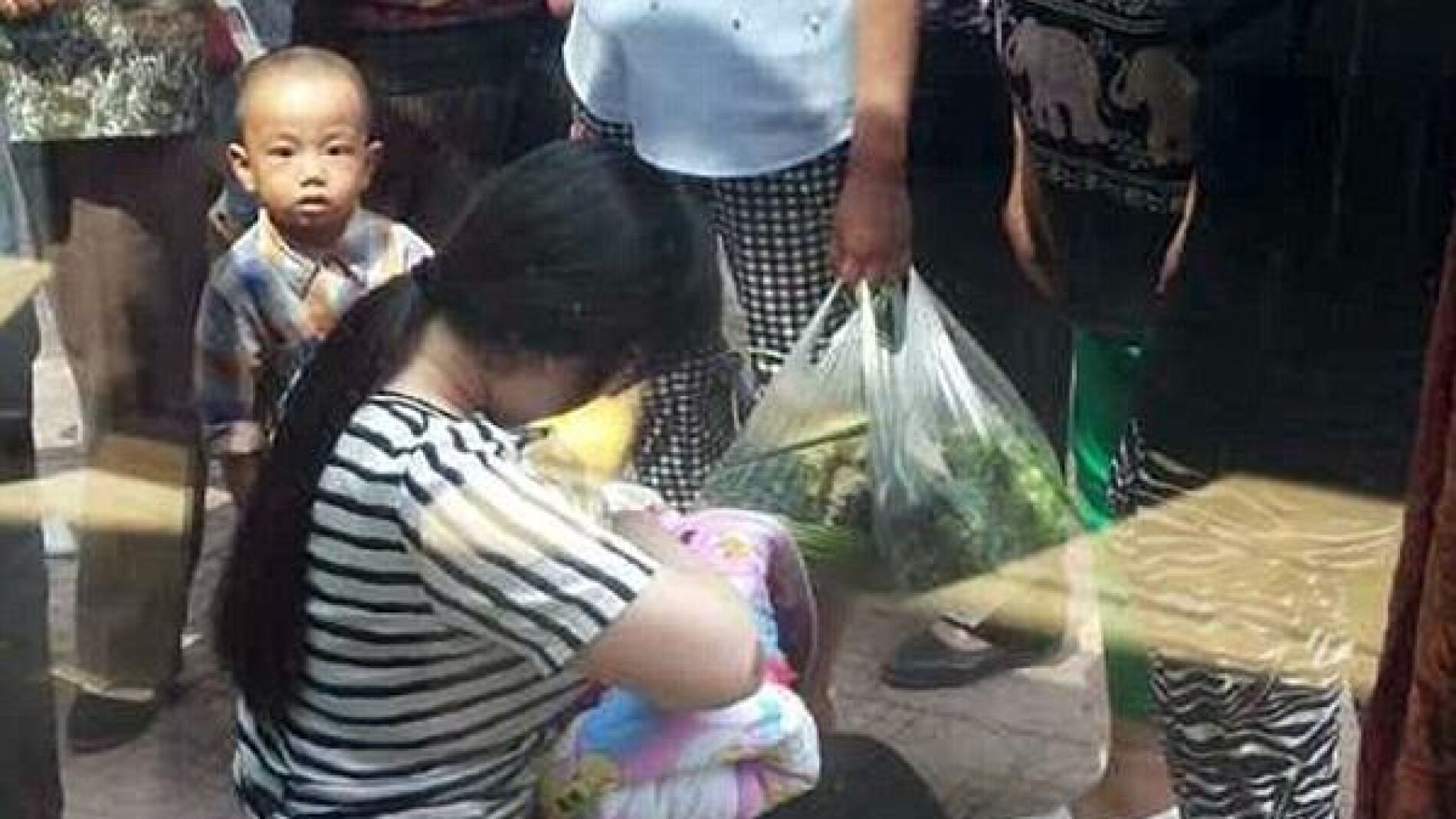 La mujer amamanta al peque&ntilde;o en la calle