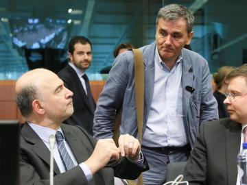 El comisario de Asuntos Económicos, Pierre Moscovici, conversa con el ministro giego Euclides Tsakalotos.