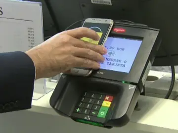 Un hombre paga en un datáfono con su 'smartphone'. Un hombre paga en un datáfono con su 'smartphone'.