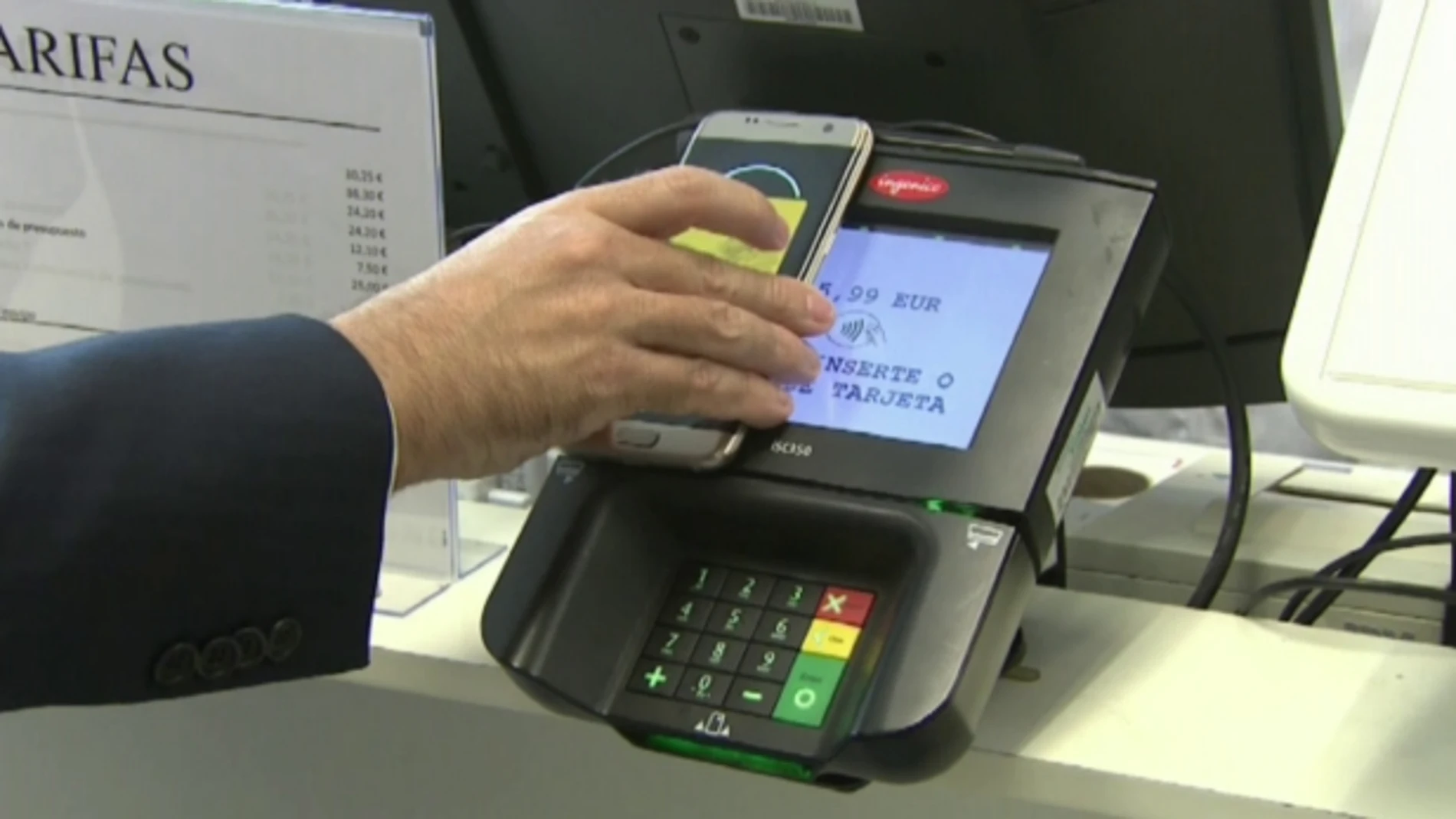 Un hombre paga en un datáfono con su 'smartphone'. Un hombre paga en un datáfono con su 'smartphone'.