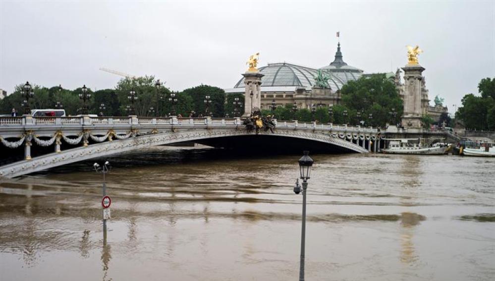 Vista general de lámparas parcialmente sumergidas junto al puente Alexandre III en el río Sena en París