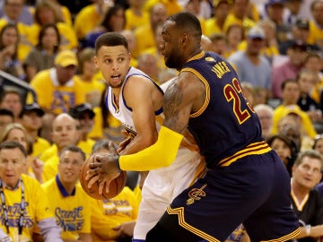 Stephen Curry aguanta el balón ante la defensa de LeBron James