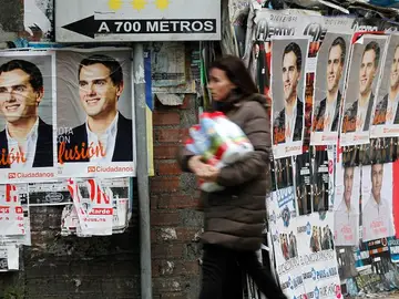 Una mujer pasa por una calle con los carteles de Albert Rivera. Una mujer pasa por una calle con los carteles de Albert Rivera.