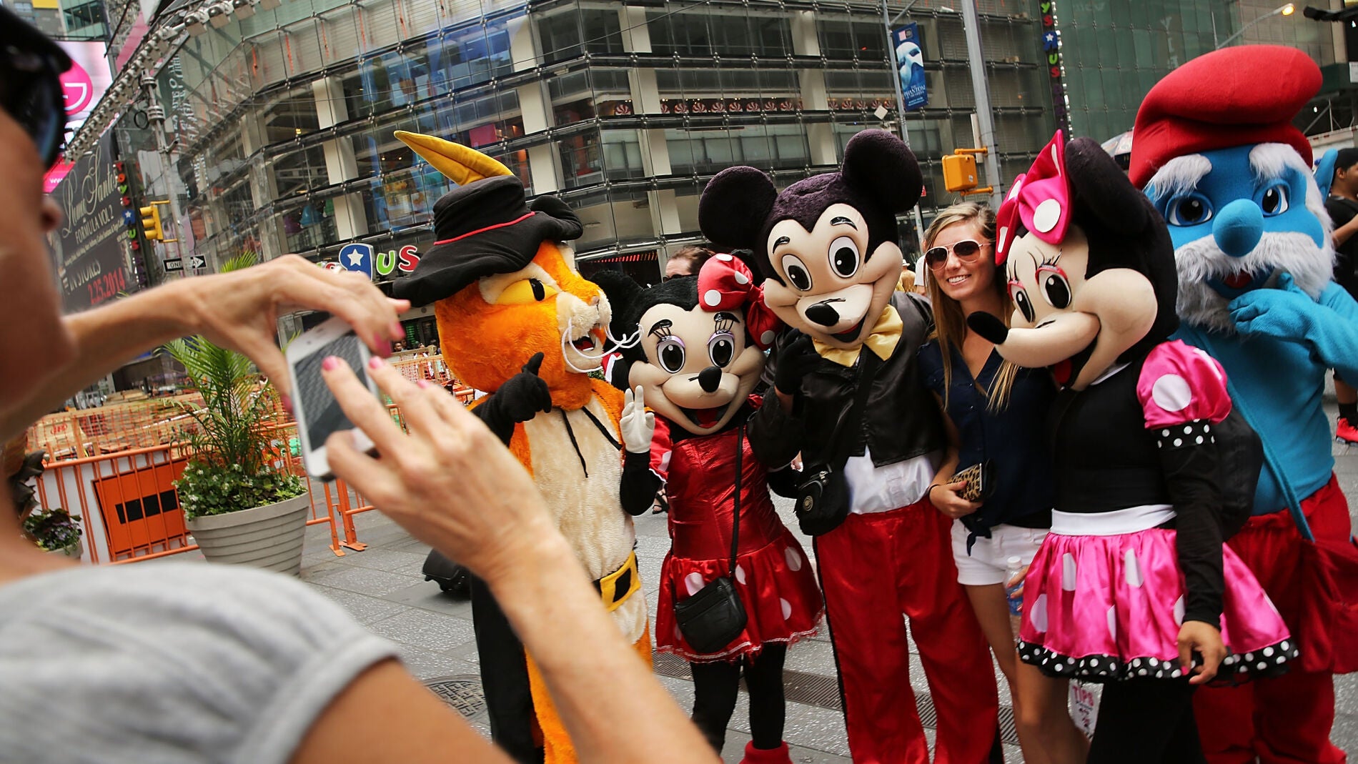 Personajes en Times Square fotografi&aacute;ndose con una turista