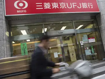 Un hombre pasea por una oficina del Mitsubishi Tokyo-UFJ. Un hombre pasea por una oficina del Mitsubishi Tokyo-UFJ.