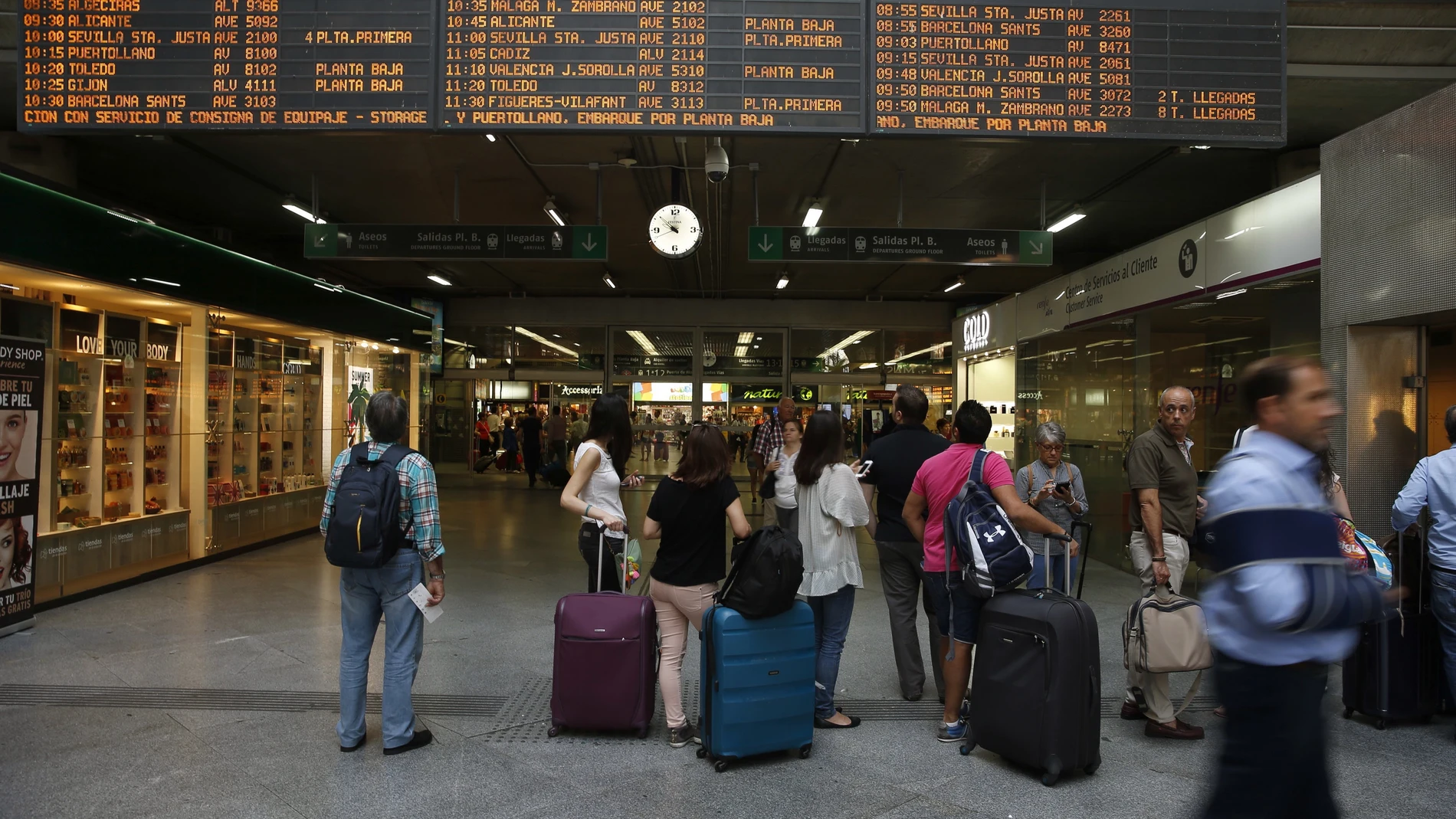 Viajeros miran los horarios en la estación madrileña de Atocha Viajeros miran los horarios en la estación madrileña de Atocha