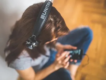 Una mujer escuchando con auriculares Una mujer escuchando con auriculares