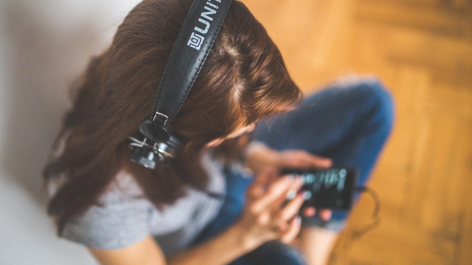 Una mujer escuchando con auriculares Una mujer escuchando con auriculares