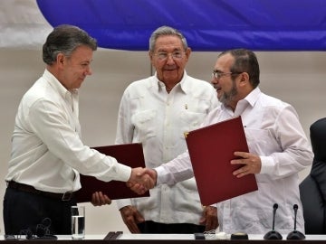El líder de las FARC en Cuba, Rodrigo Londoño alias "Timochenko" y el presidente de Colombia, Juan Manuel Santos, junto al presidente de Cuba, Raúl Castro
