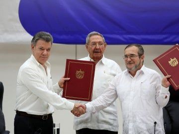 El presidente de Colombia, Juan Manuel Santos, y el líder de las FARC, Rodrigo Londoño 'Timochenko', ante Raúl Castro