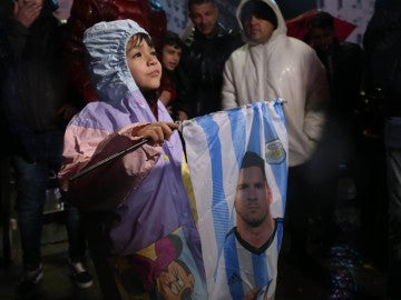 Un niño sostiene una bandera con la cara de Leo Messi