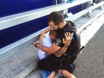 El agente abraza al chico tras el rescate.