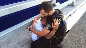 El agente abraza al chico tras el rescate.