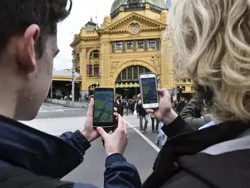 Dos estudiantes prueban el nuevo juego 'Pokémon Go' en su móvil Dos estudiantes prueban el nuevo juego 'Pokémon Go' en su móvil