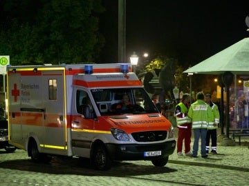 Una ambulancia en el lugar donde un refugiado sirio muri&oacute; hoy al detonar un artefacto explosivo en Ansbach, Alemania, causando doce heridos
