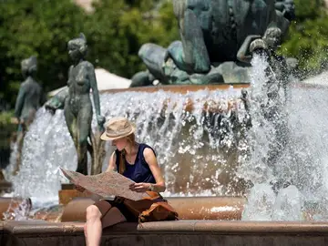 Una turista junto a una fuente Una turista junto a una fuente