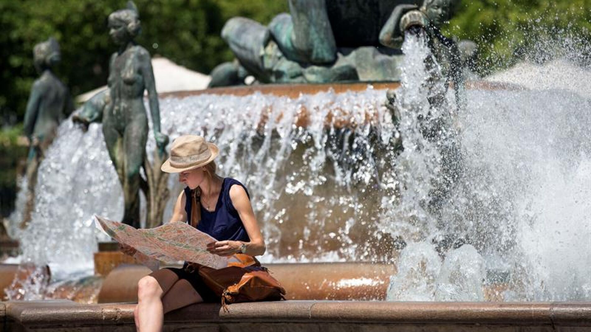 Una turista junto a una fuente