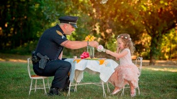 La pequeña de dos años toma el té con el Policía que le salvó la vida.