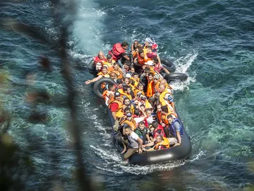Embarcación de inmigrantes llegando a la costa Embarcación de inmigrantes llegando a la costa