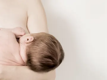 Bebé mamando del pecho de su madre Bebé mamando del pecho de su madre