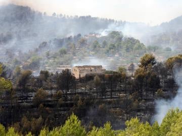 Una masía con el entorno quemado a causa del incendio en La Pobla de Montornès, Tarragona.