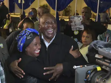 El vicepresidente sudafricano, Cyril Ramaphosa (c), abrazando a una de sus votantes a su llegada a la sede de su partido El vicepresidente sudafricano, Cyril Ramaphosa (c), abrazando a una de sus votantes a su llegada a la sede de su partido