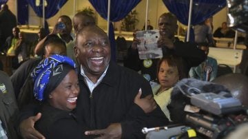 El vicepresidente sudafricano, Cyril Ramaphosa (c), abrazando a una de sus votantes a su llegada a la sede de su partido