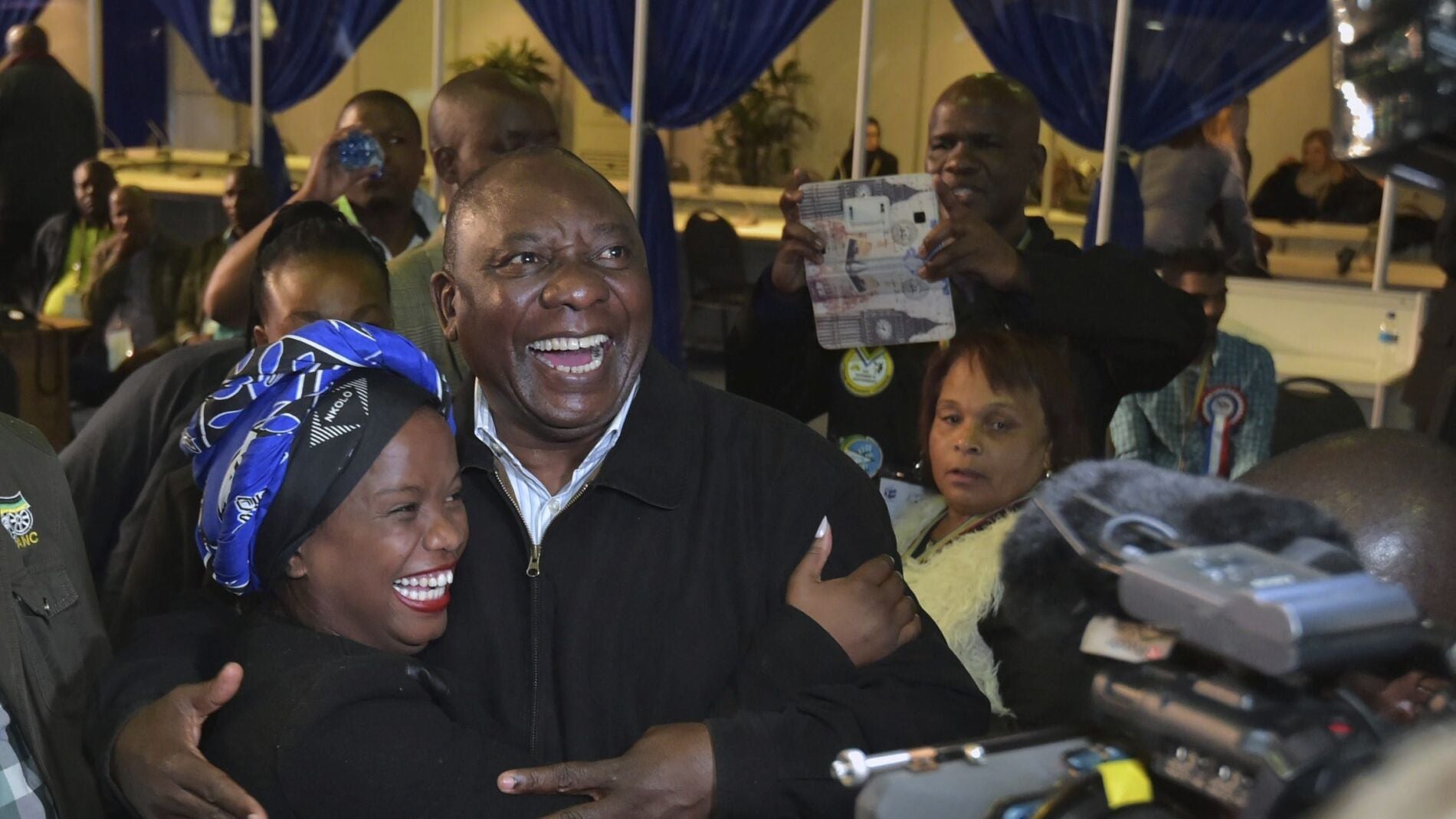 El vicepresidente sudafricano, Cyril Ramaphosa (c), abrazando a una de sus votantes a su llegada a la sede de su partido